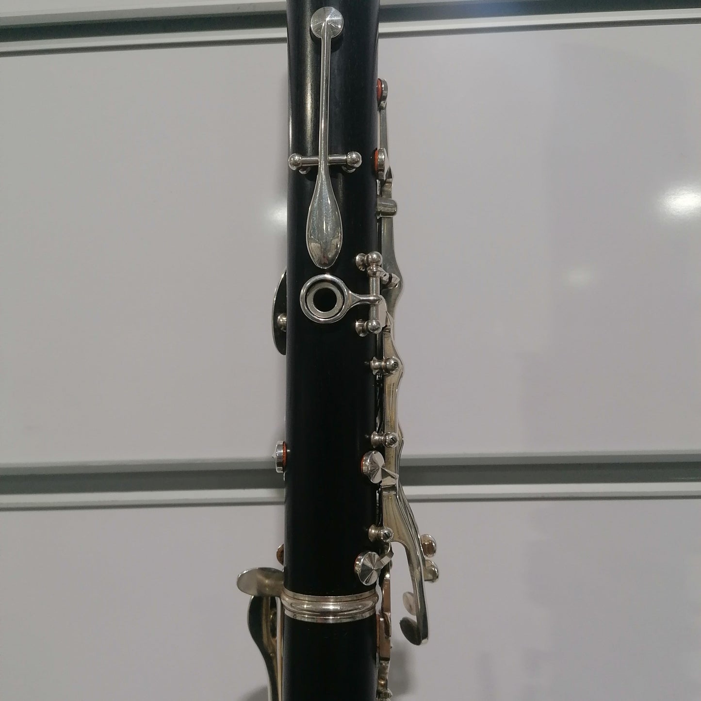 Black clarinet with silver keys on a white background