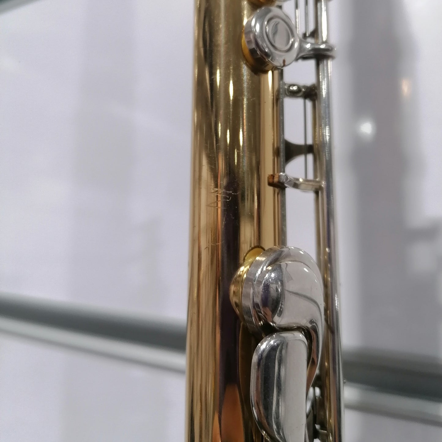 Close-up of a gold and silver musical instrument on a white background