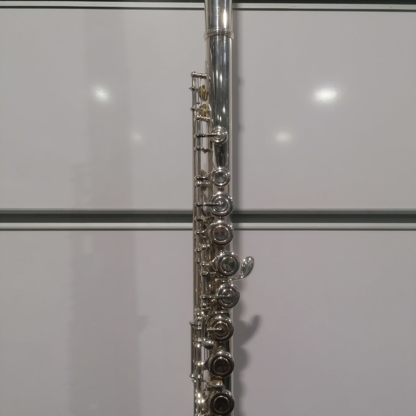 Close-up of a silver flute against a white background