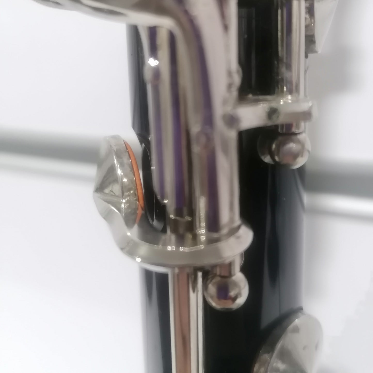 Close-up of a silver wind instrument mouthpiece on a white background