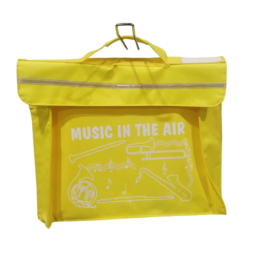Yellow bag with 'Music in the Air' text and graphic on a white wall.