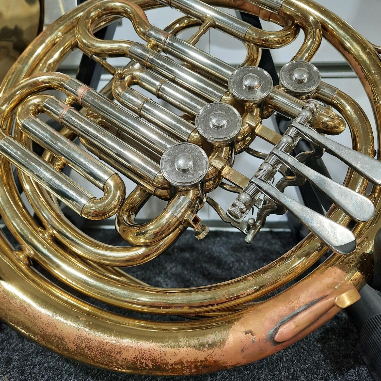 Close-up of a brass musical instrument, likely a French horn, with intricate details.