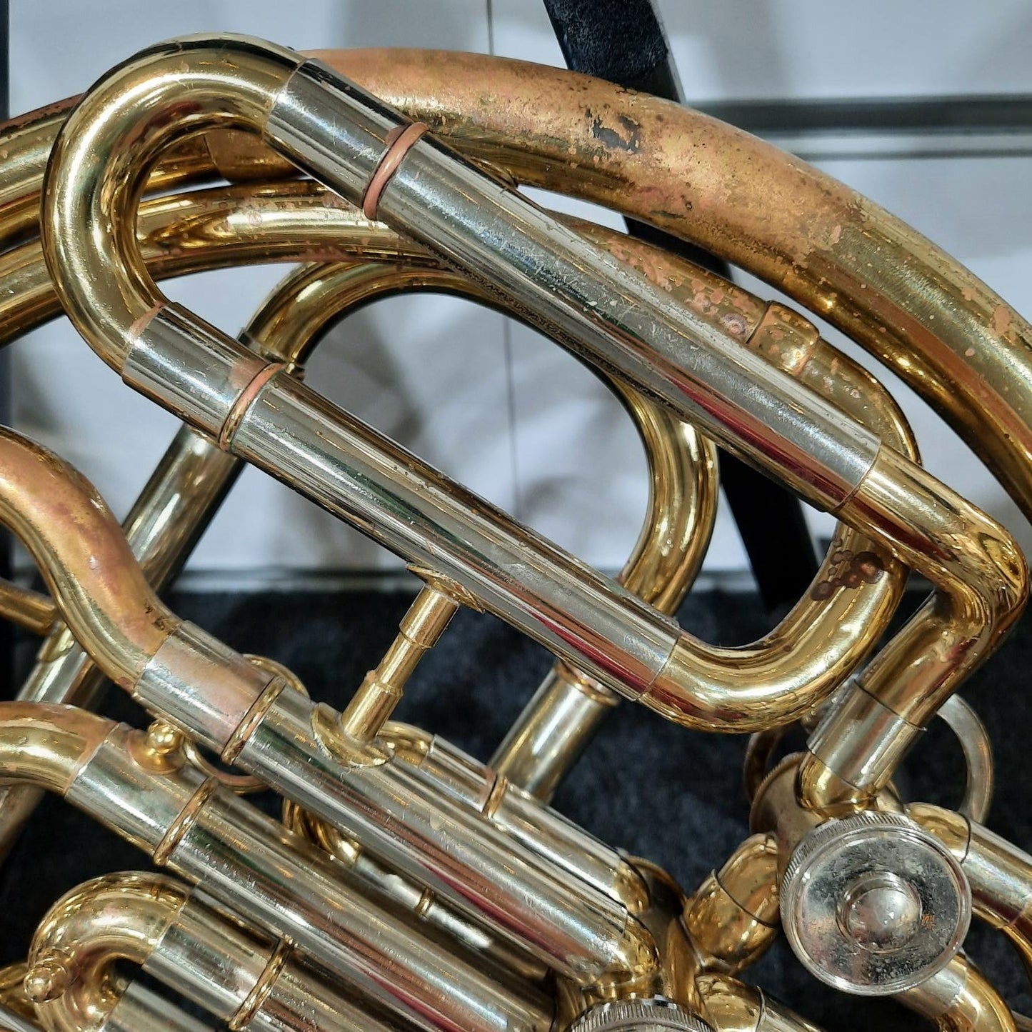 Close-up of a brass musical instrument, likely a French horn, with a blurred background.