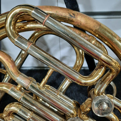Close-up of a brass musical instrument, likely a French horn, with a blurred background.