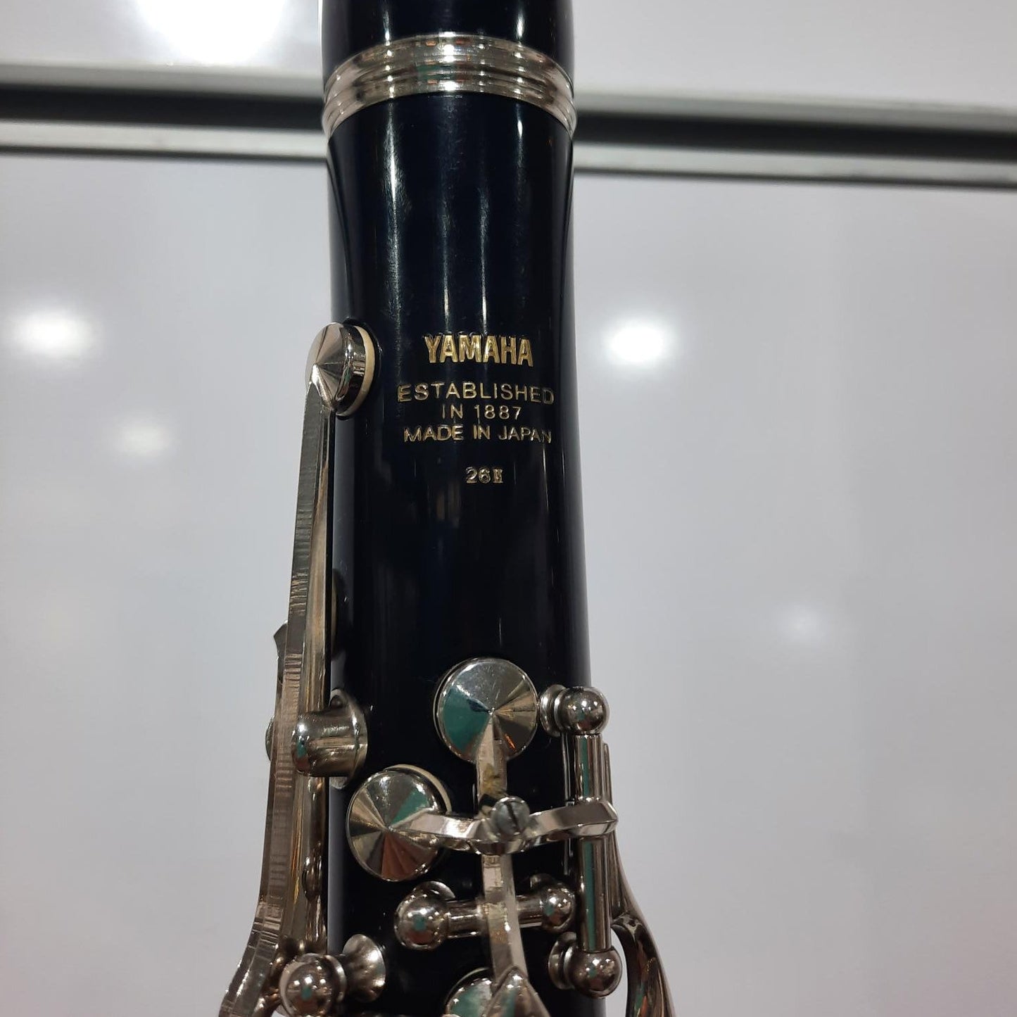 Clarinet with silver keys and black body on a reflective surface
