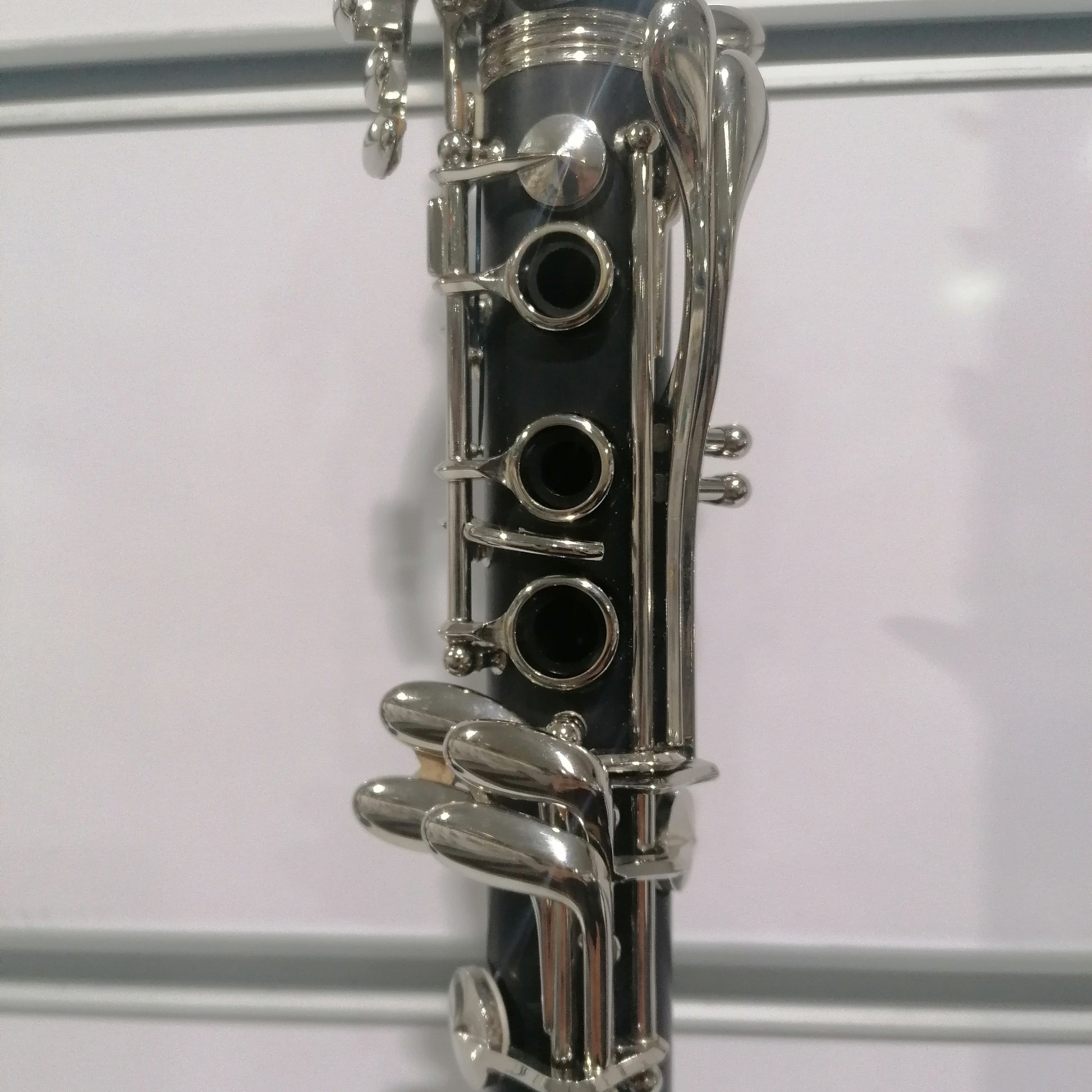 Close-up of a clarinet with silver keys on a white background