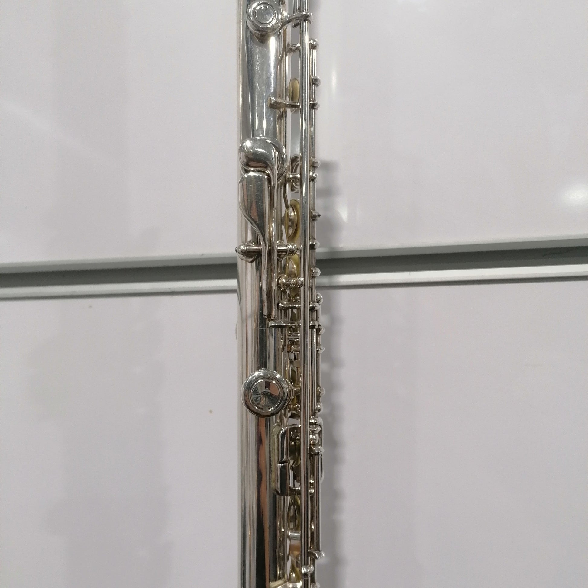 Close-up of a silver flute on a white background