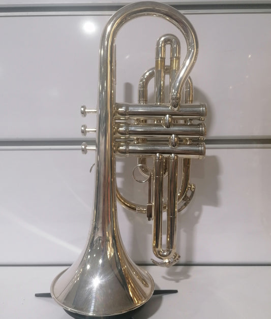 Silver trumpet on a stand against a white background