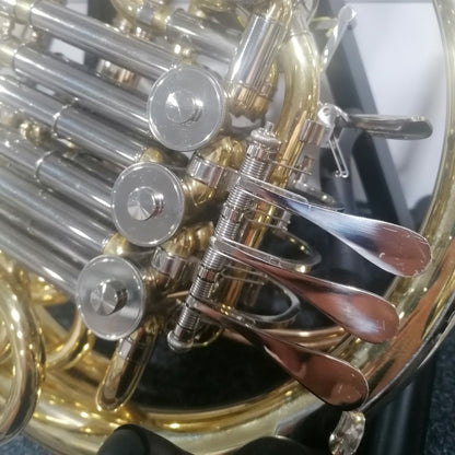 Close-up of a brass instrument, likely a French horn, with visible keys and valves.