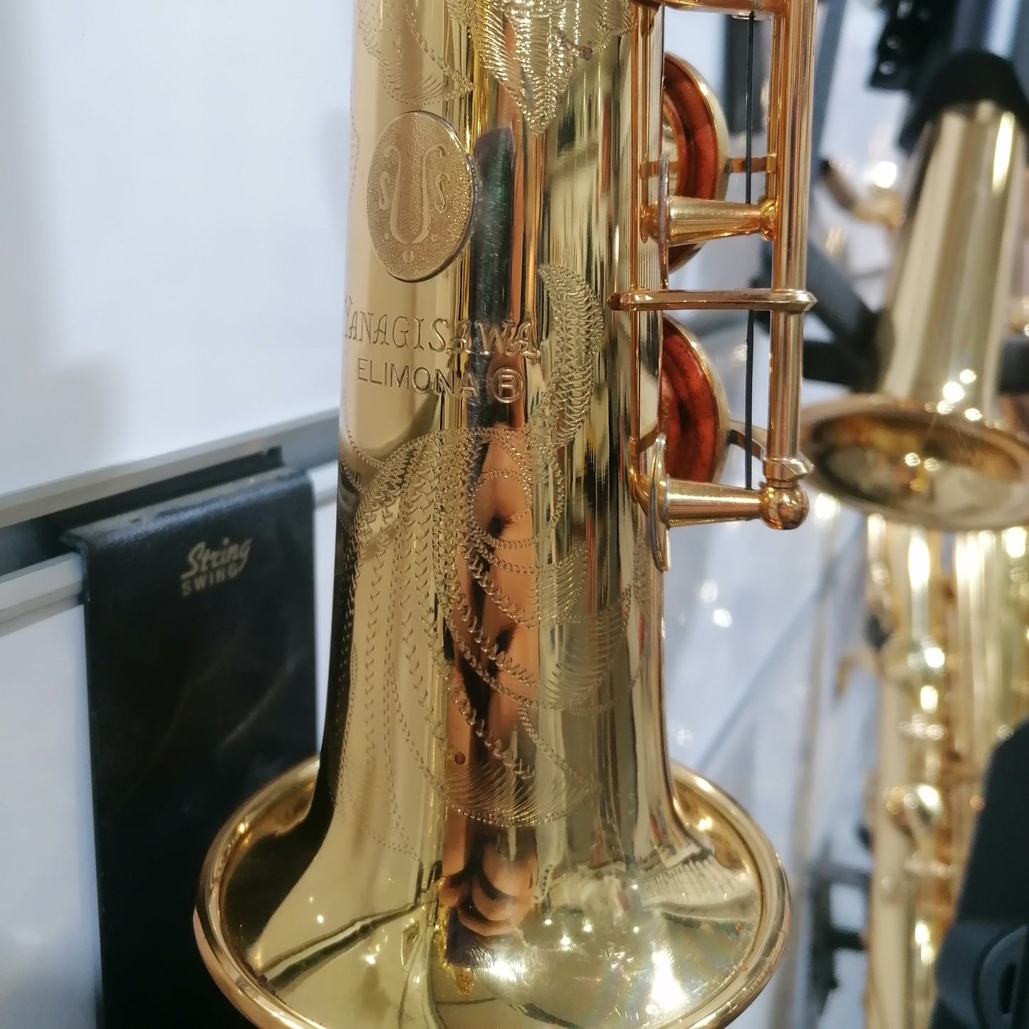 Close-up of a gold saxophone with a blurred background
