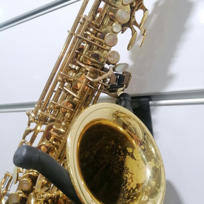 Close-up of a gold saxophone with a white background