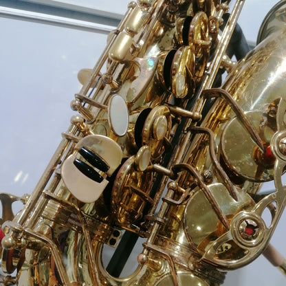 Close-up of a gold saxophone with a clear background