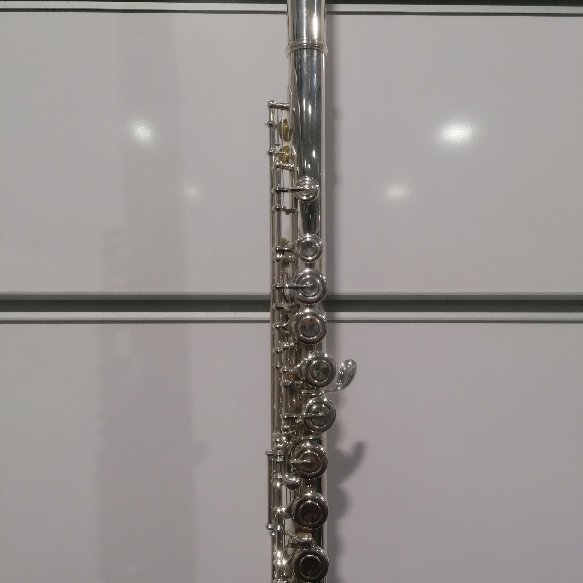 Close-up of a silver flute against a white background