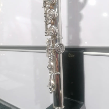Silver flute on a stand with a white background