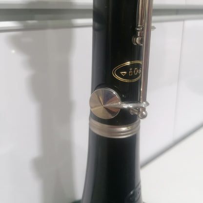 Close-up of a black clarinet with silver keys on a white background