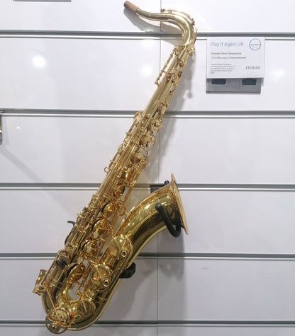 Gold saxophone on a white wall with price tags